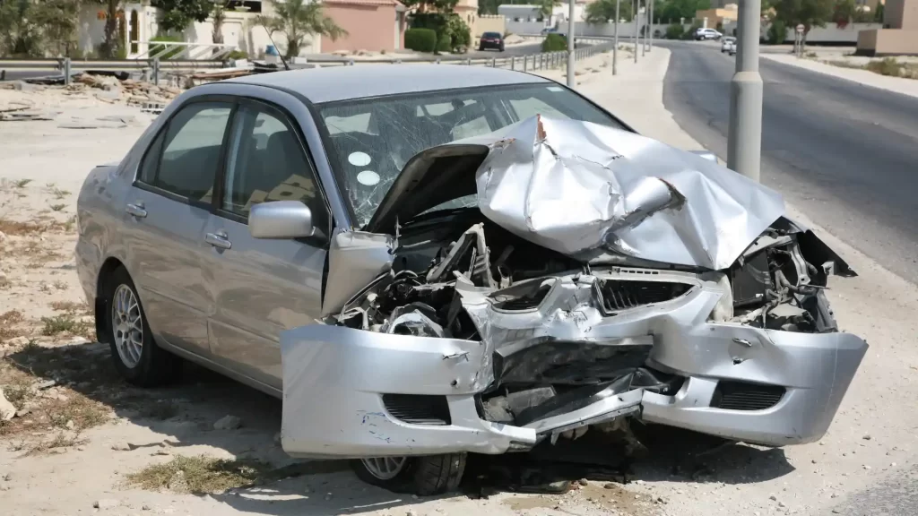 Silver car with severe front-end damage after crash.